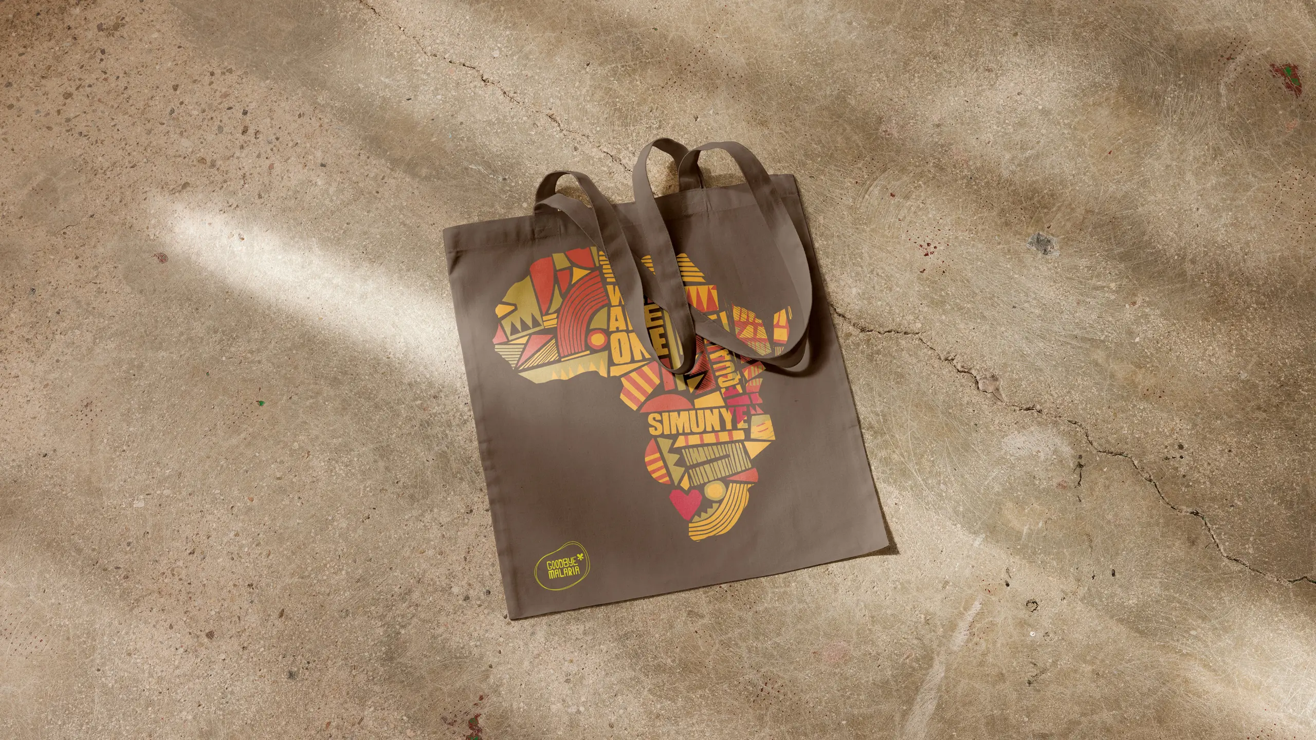 Goodbye Malaria tote bags carrying the illustrated Africa campaign graphic