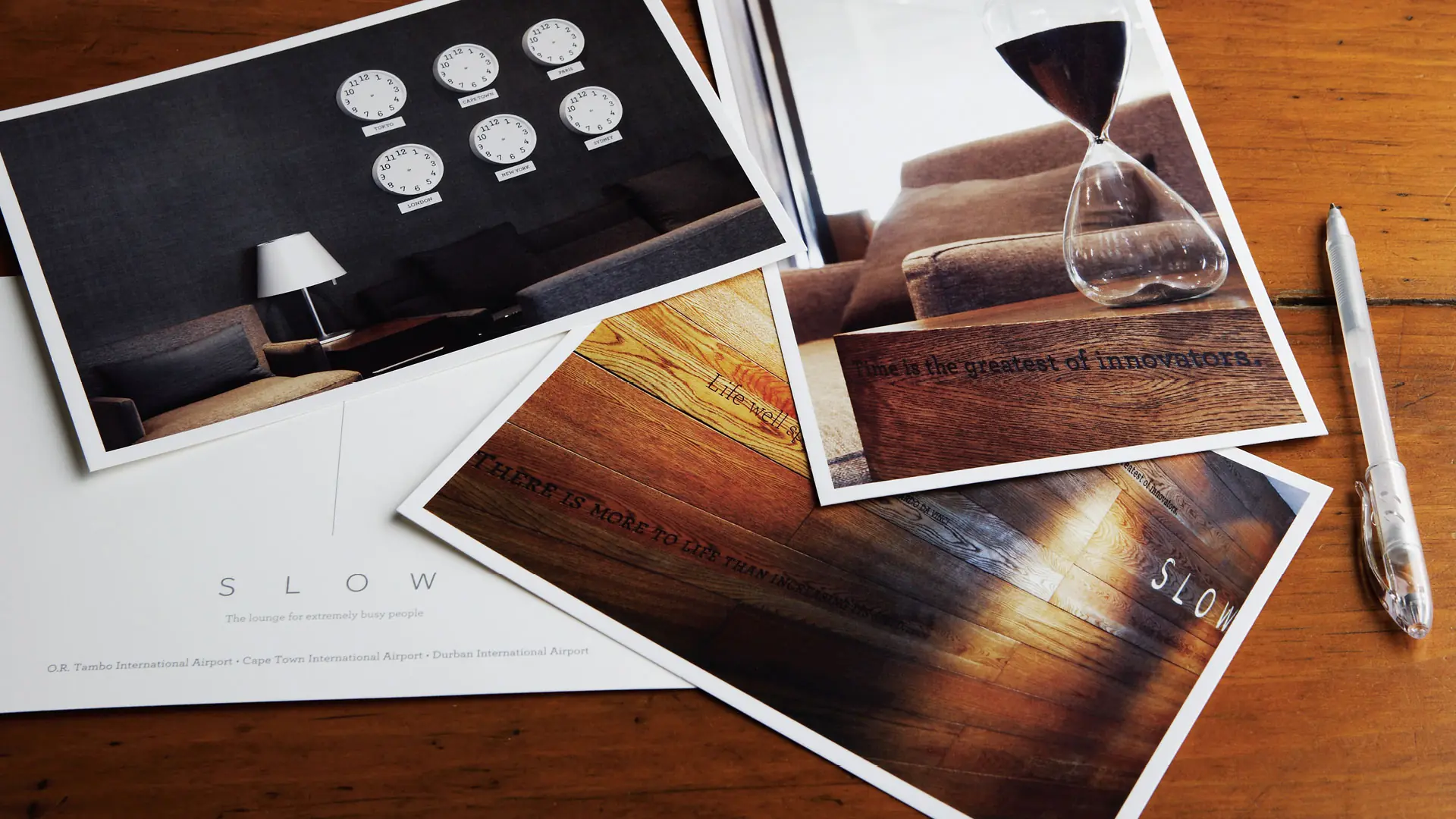 SLOW stationery and photographic cards arranged across a timber table